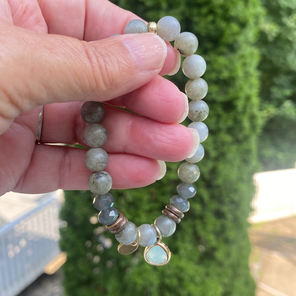 Green beaded stretch bracelet with hanging charm.